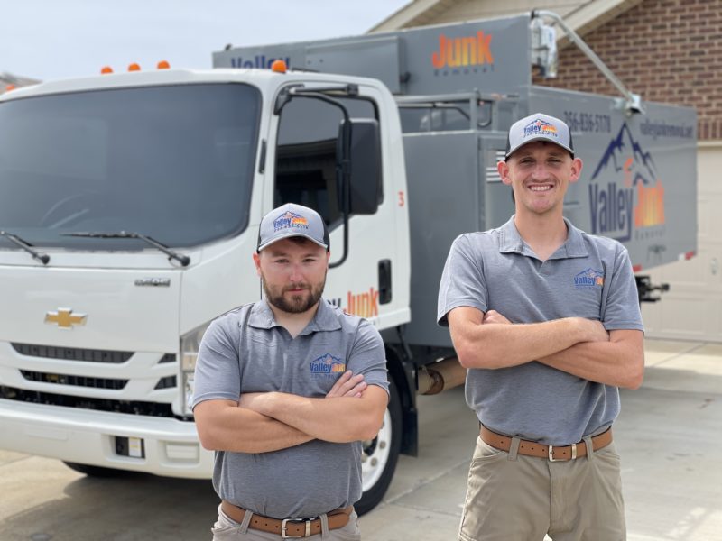 valley junk removal experts standing smiling in front of truck. friendly junk removal services in alabama