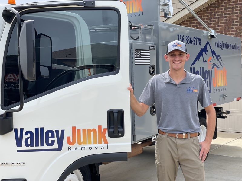 valley junk removal expert standing smiling in front of truck. friendly junk removal services in alabama