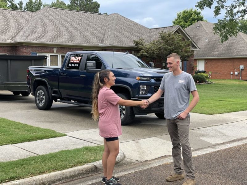 valley junk removal pro shaking hands with junk removal customer about a quote