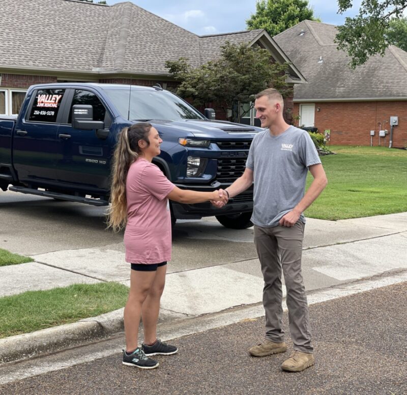Junk removal professional shaking hands with a happy customer during after a piano removal