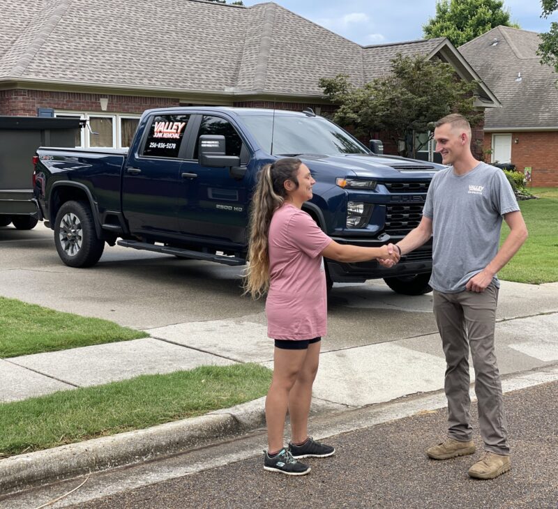 Junk removal professional shaking hands with a happy customer during junk removal services in Albertville AL
