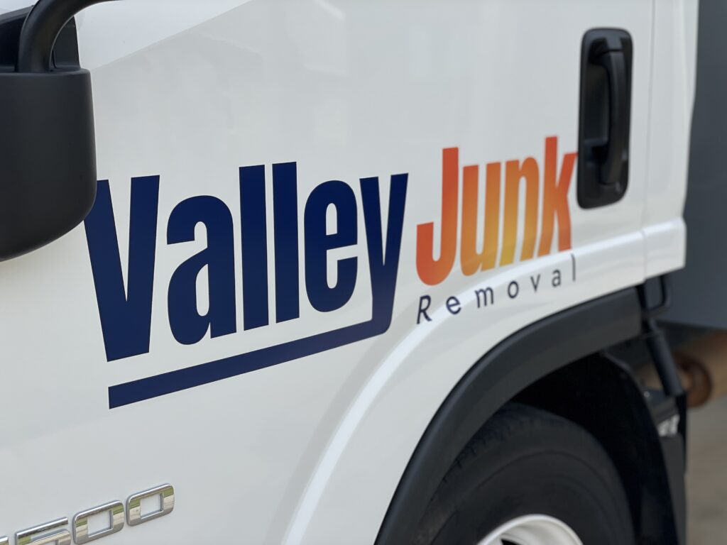 A close-up of the logo on the side of a white commercial vehicle, reading 'Valley Junk Removal', indicating the brand identity of a junk removal service.